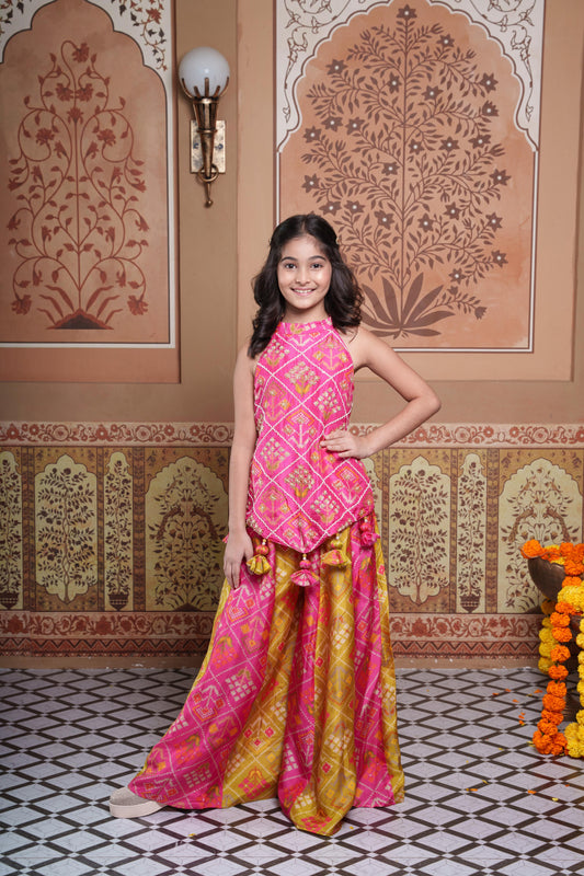 Vibrant pink and green silk two-piece set featuring a printed halter top with playful tassels and a flowy palazzo