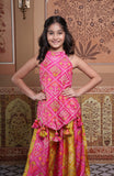Vibrant pink and green silk two-piece set featuring a printed halter top with playful tassels and a flowy palazzo