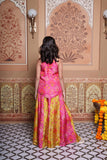 Vibrant pink and green silk two-piece set featuring a printed halter top with playful tassels and a flowy palazzo
