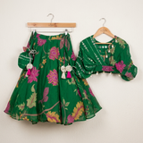Elegant green Chinnon Chiffon 3-piece festive set with a floral top, flared lehenga and matching potli