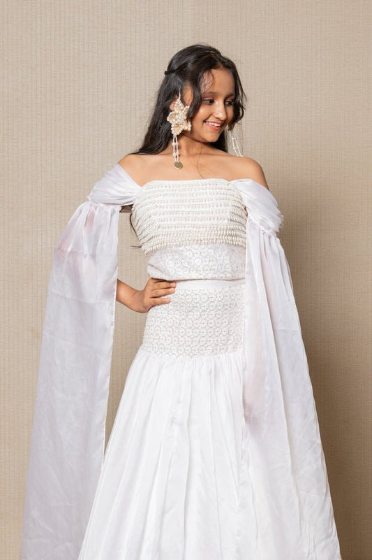 Elegant white off - the - shoulder Lahenga with intricate beadwork and flowing sleeves, perfect for a timeless and graceful look at any formal event. - Kirti Agarwal