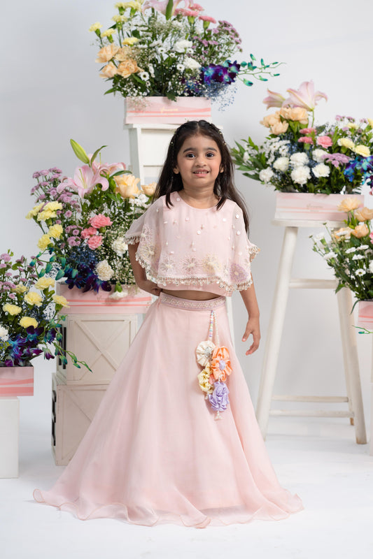 Blush pink pearl embellished cape top with flowing lehenga for girls