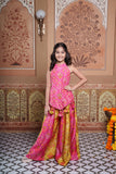 Vibrant pink and green silk two-piece set featuring a printed halter top with playful tassels and a flowy palazzo