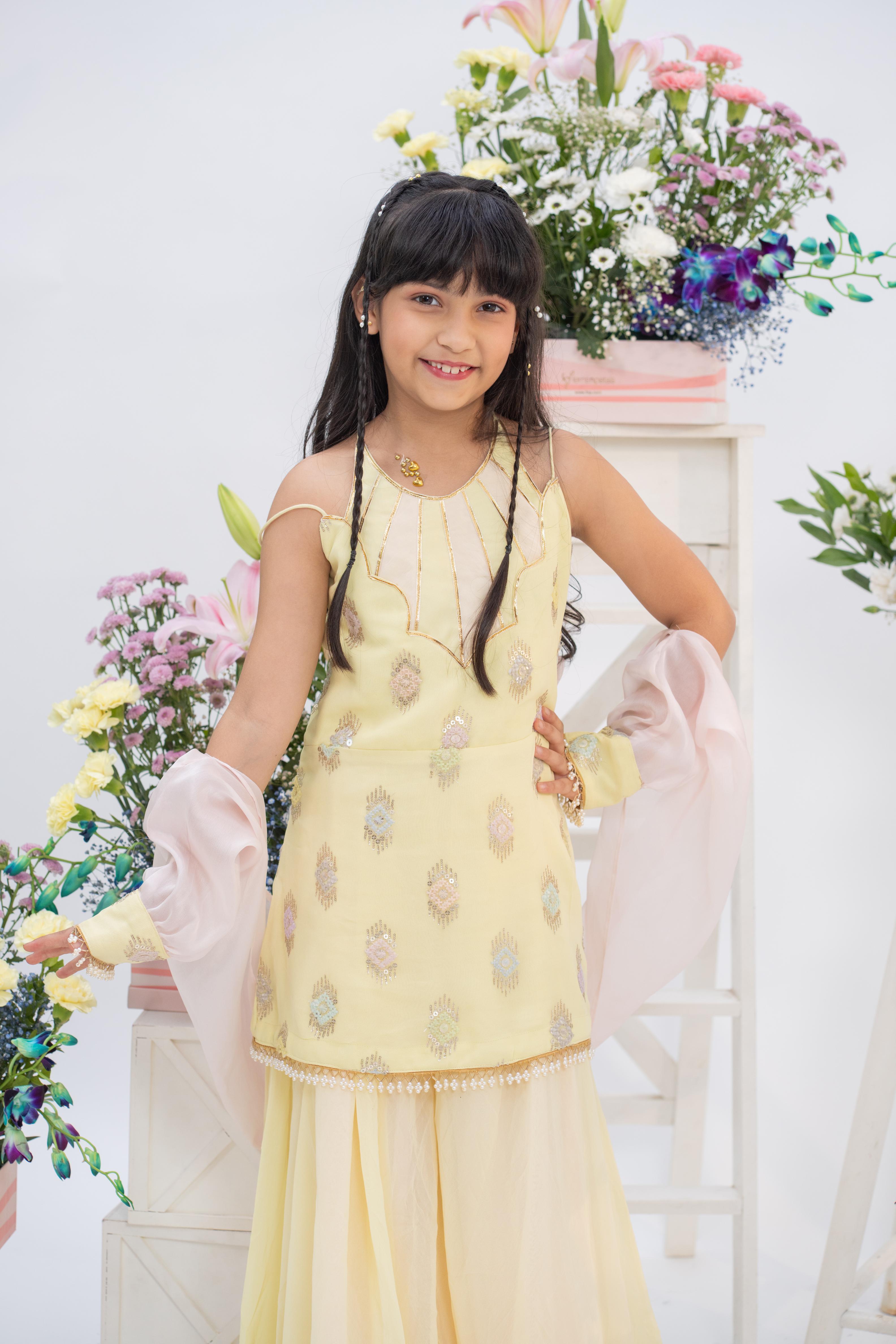 Kids festive pastel yellow kurti and sharara set by Kirti Agarwal