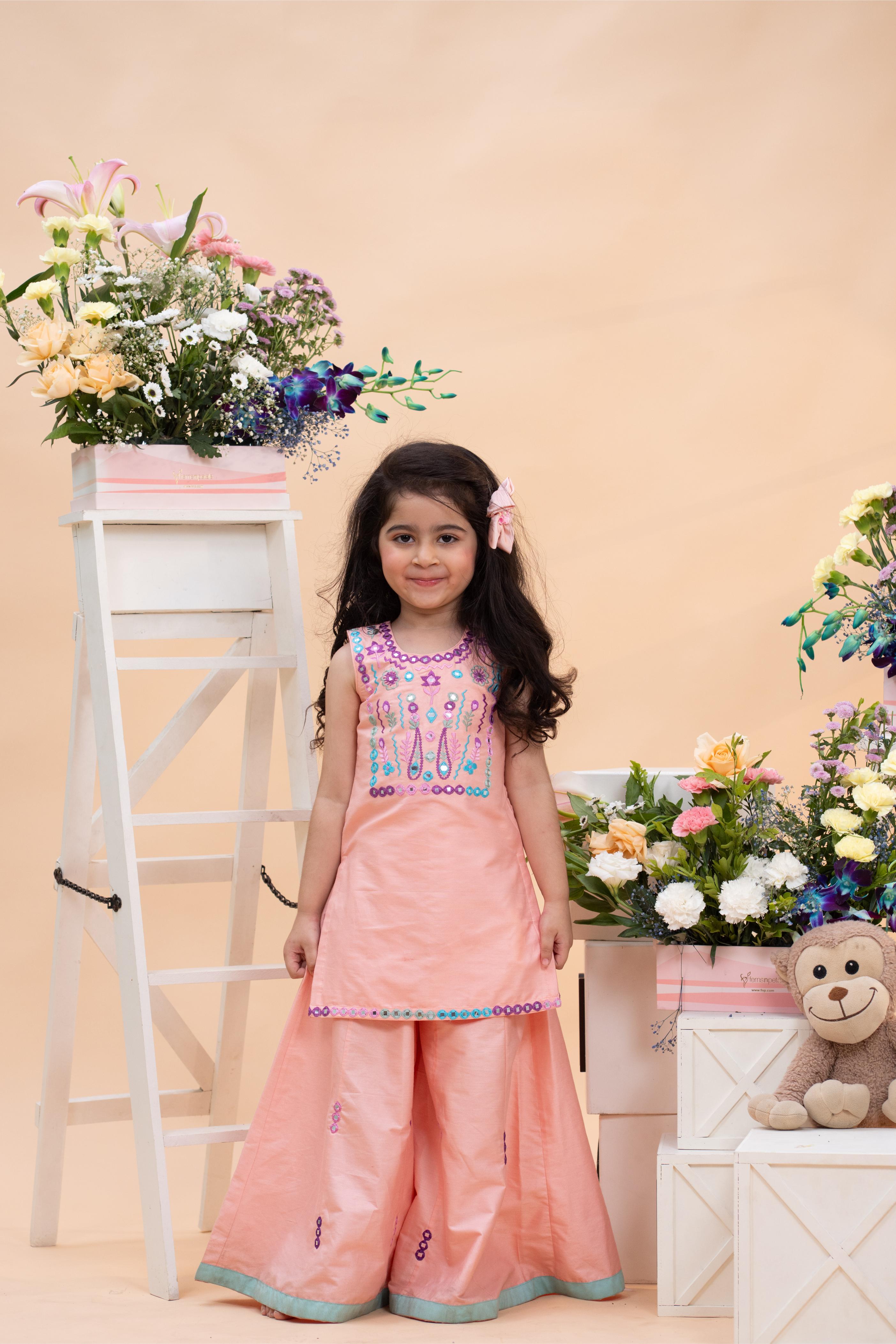 peach embroidered kurti with flared palazzo set for girls by Kirti Agarwal