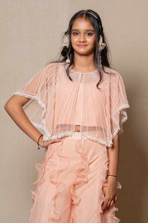 Chic Peach ensemble with beaded cape and ruffled palazzo pants, perfect for a stylish and elegant look at any occasion. - Kirti Agarwal