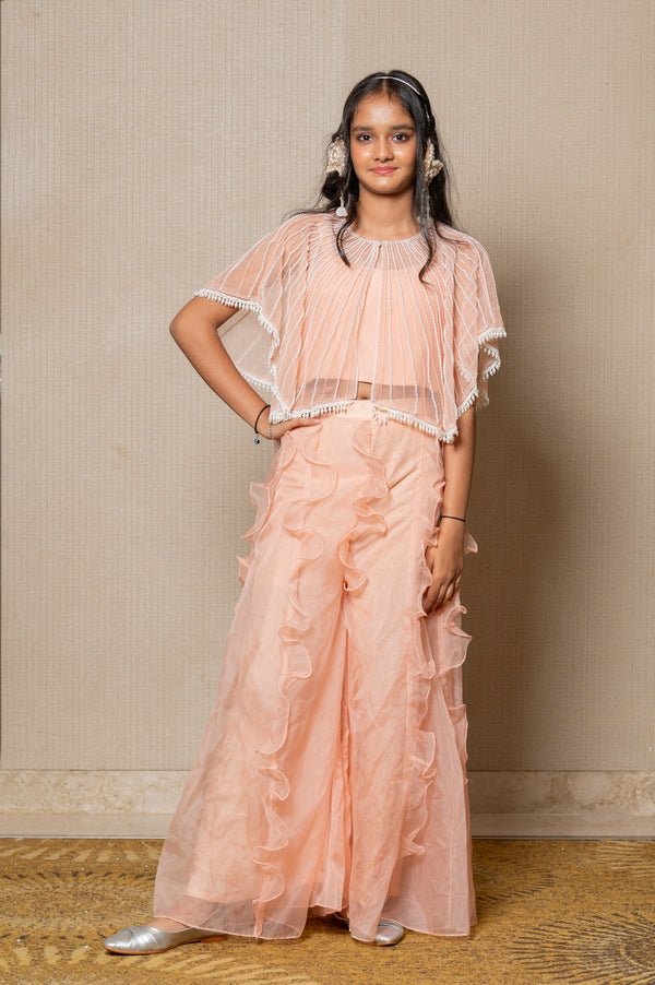 Chic Peach ensemble with beaded cape and ruffled palazzo pants, perfect for a stylish and elegant look at any occasion. - Kirti Agarwal