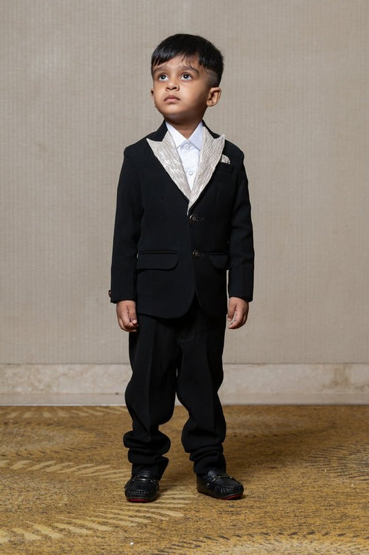 Classic black blazer with a champagne metallic - textured lapel, paired with matching pants and a crisp white shirt for a sophisticated formal look - Kirti Agarwal