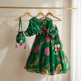 Elegant green Chinnon Chiffon 3-piece festive set with a floral top, flared lehenga and matching potli