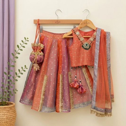 Stunning rust orange 4-piece tissue silk lehenga set with embellished crop top, net dupatta and matching potli bag