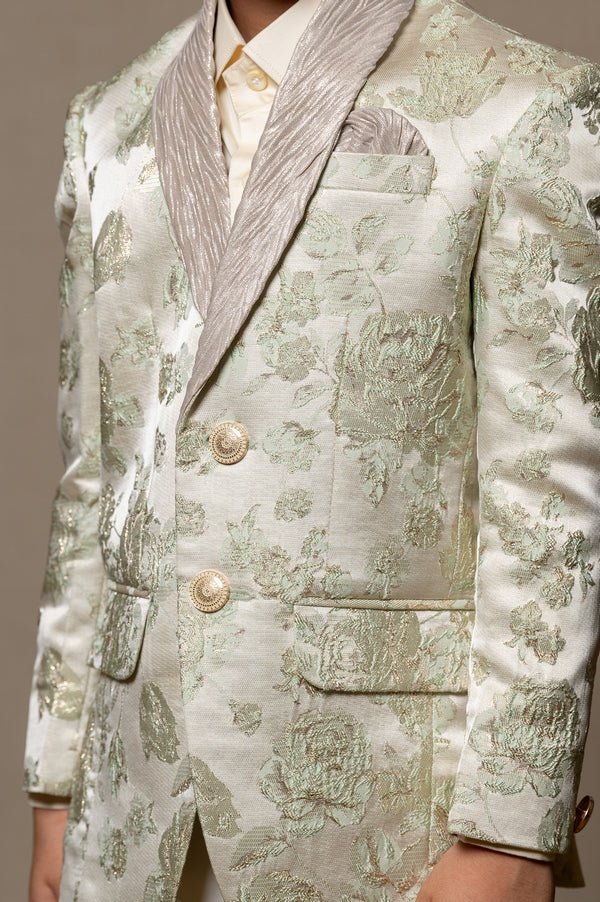 Elegant brocade suit jacket with floral patterns paired with crisp white trousers and a classic ivory shirt for a regal and sophisticated look