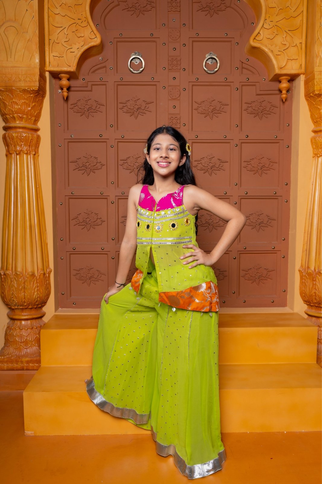 Girls festive sharara set in vibrant pink and lime green, crafted in soft Georgette with Brocade Silk accents, featuring mirror work, sequins, and elegant detailing – perfect ethnic wear for weddings, parties, and celebrations - Kirti Agarwal
