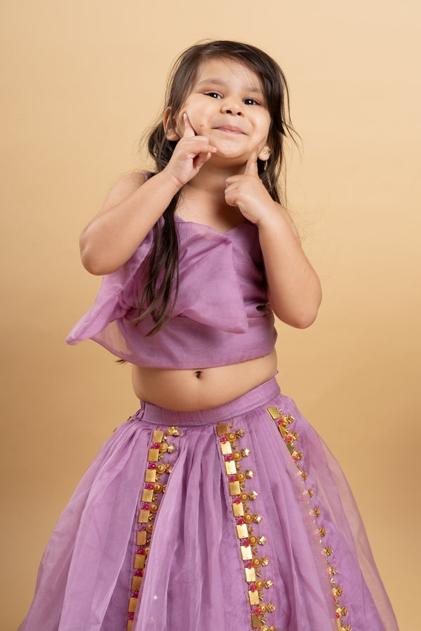 Chic Lavender lehenga with an asymmetrical top, adorned with gold and pink embellishments for a modern festive look.