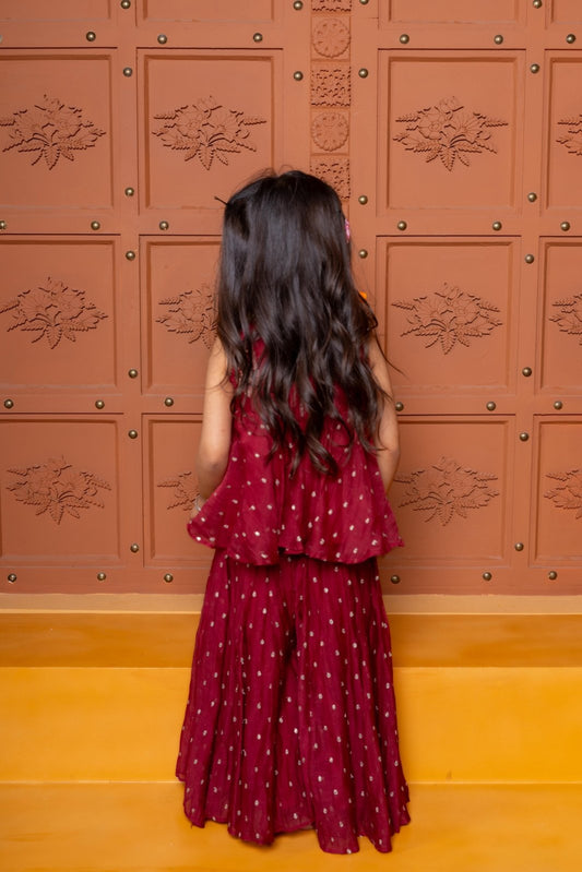 Maroon kids festive set with embroidered peplum top and flared skirt, highlighted with cowrie shell detailing. - Kirti Agarwal