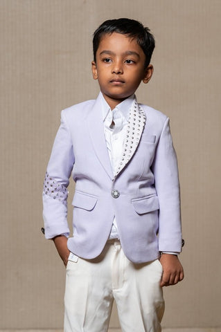 Trendy lavender blazer with metallic stud embellishments paired with classic white trousers, perfect for the modern young gentleman. - Kirti Agarwal