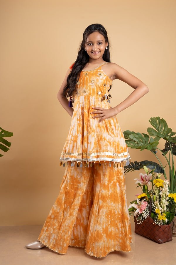 Vibrant orange tie - dye set with mirror work and tassel details, perfect for festive occasions and summer celebrations - Kirti Agarwal