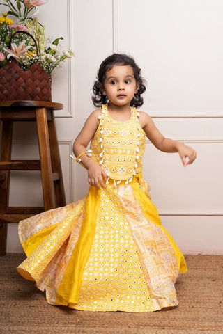 Vibrant yellow sleeveless dress with playful prints and tassel accents, perfect for festive celebrations and joyful occasions. - Kirti Agarwal