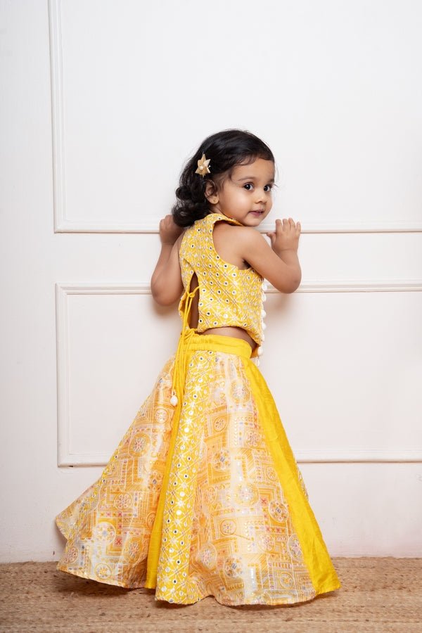 Vibrant yellow sleeveless dress with playful prints and tassel accents, perfect for festive celebrations and joyful occasions. - Kirti Agarwal